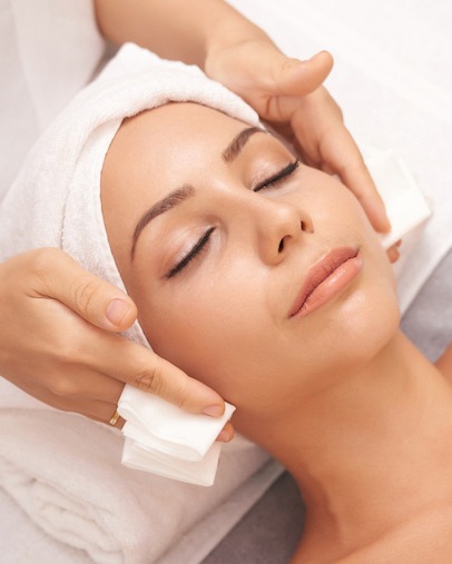 Beautiful young woman with flawless skin enjoying professional facial with Microneedling in beauty salon